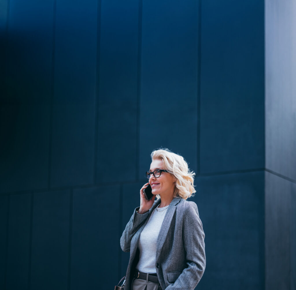 Executive leader standing against a dark blue architectural wall