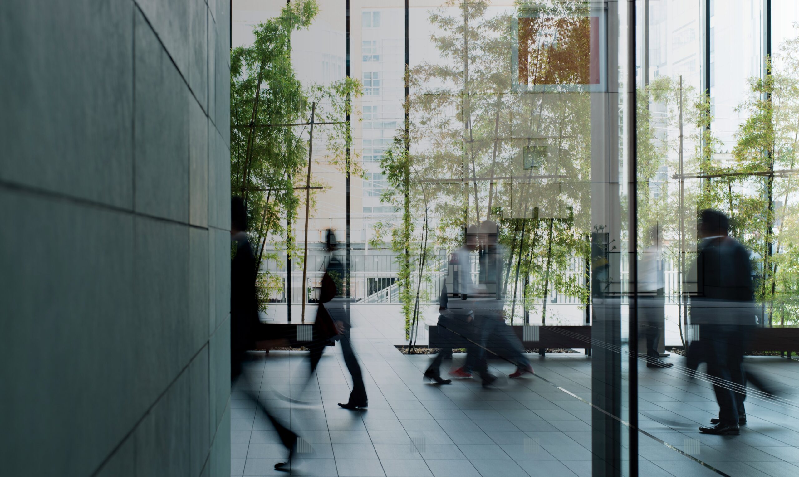 Professionals moving through a modern glass office lobby