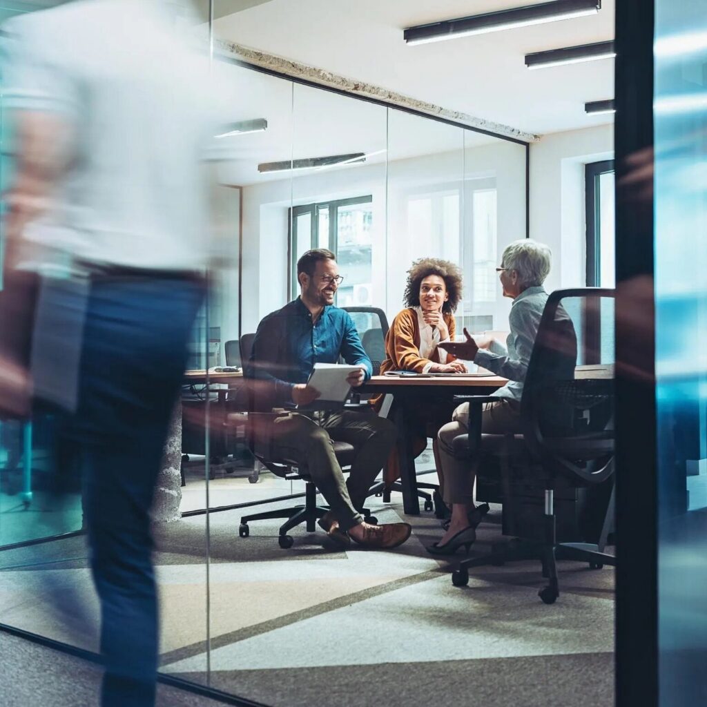 Leadership team holding a confidential discussion in a glass office