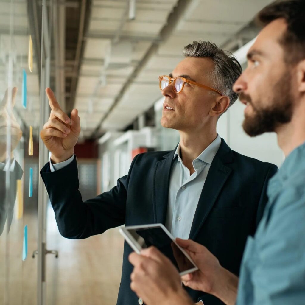 Executives mapping decision evidence on a glass board