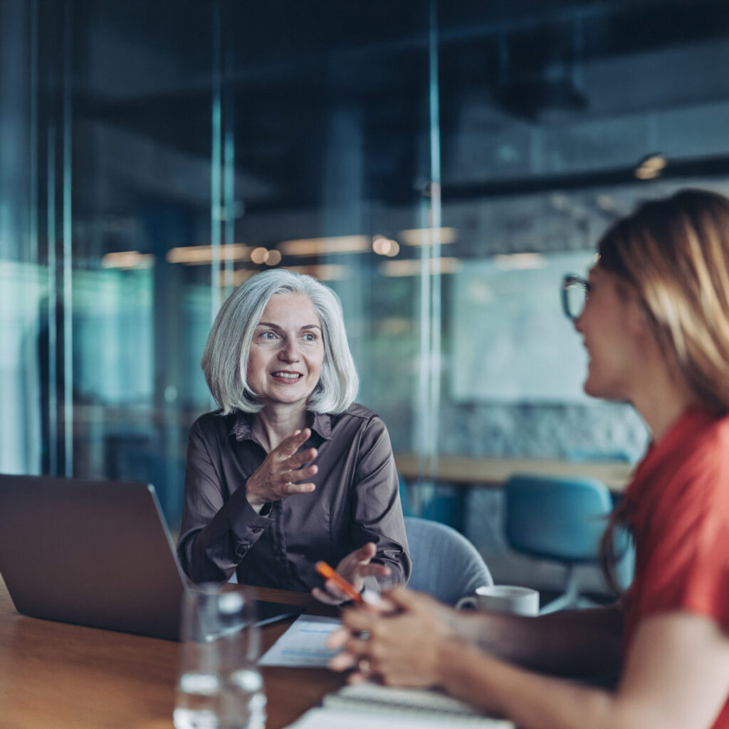 Senior female executive discussing leadership evidence with a colleague
