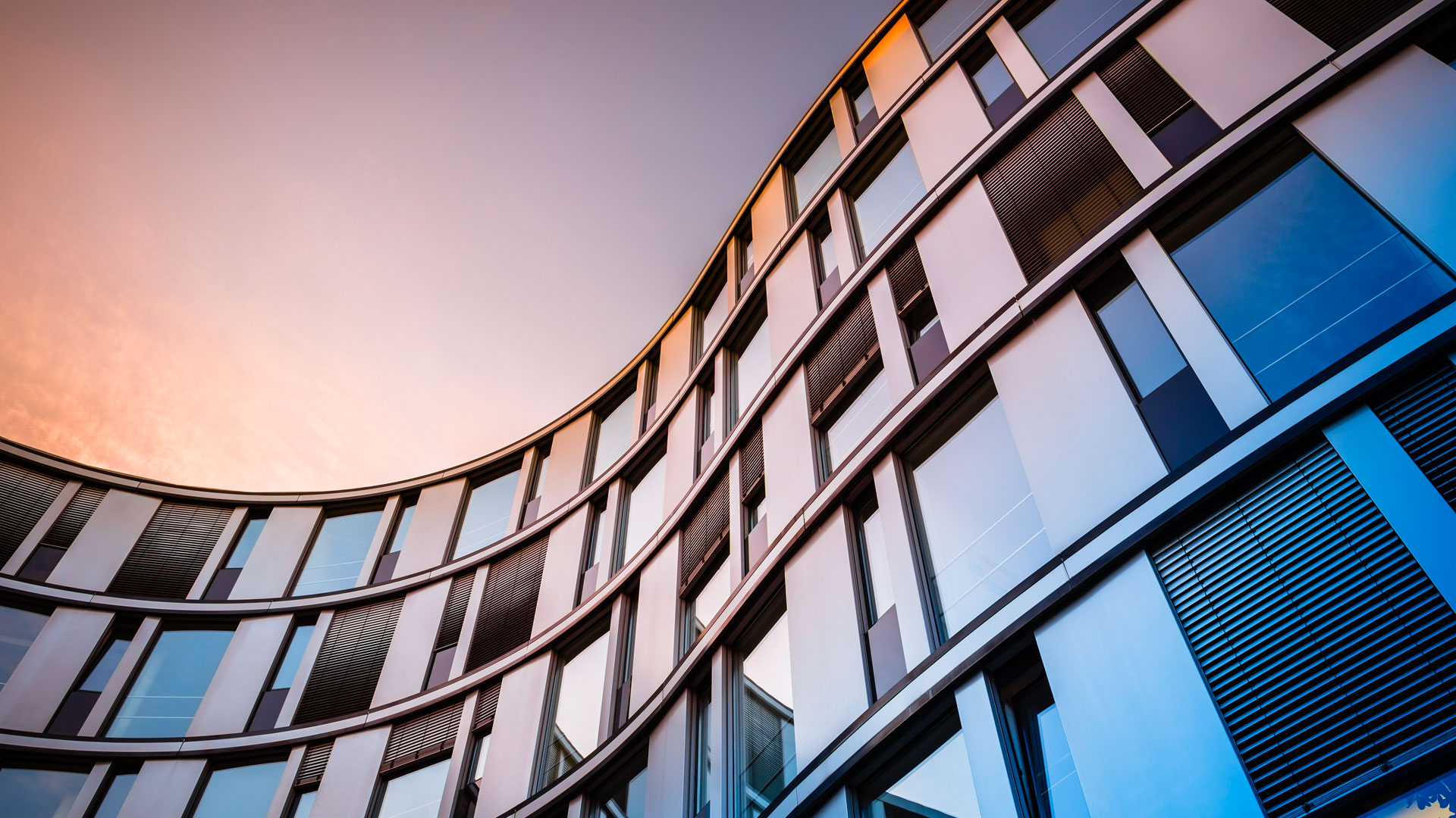 Curved modern office facade sunset