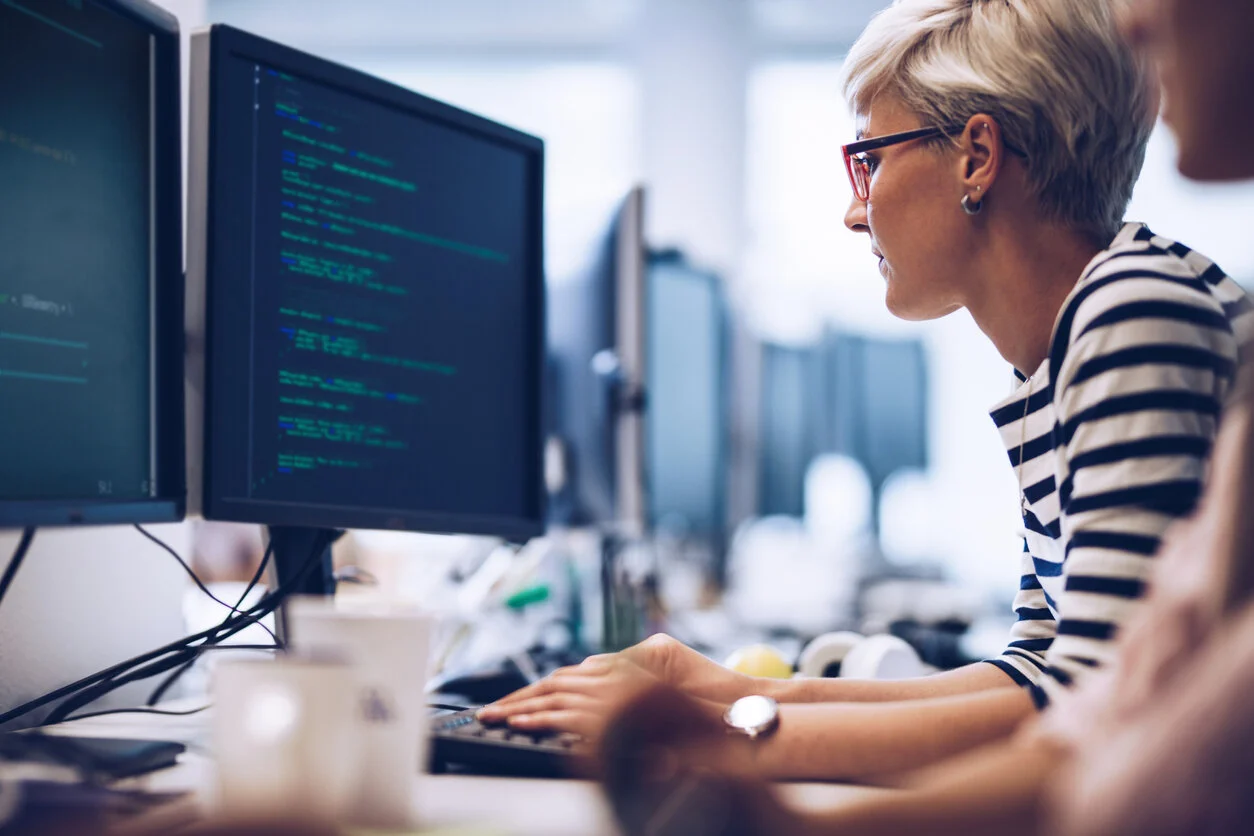 Technology leader analyzing data on computer screens